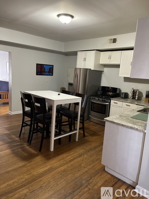 A kitchen with a table and chairs in the middle of it.