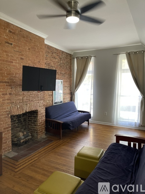 A living room with a brick wall and a fireplace.