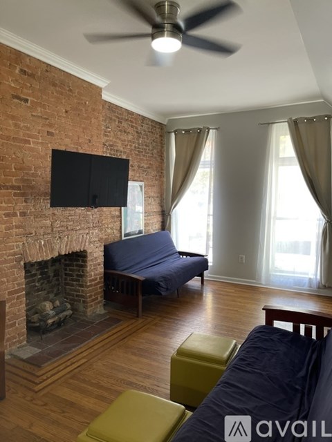 A living room with a brick wall and a fireplace.