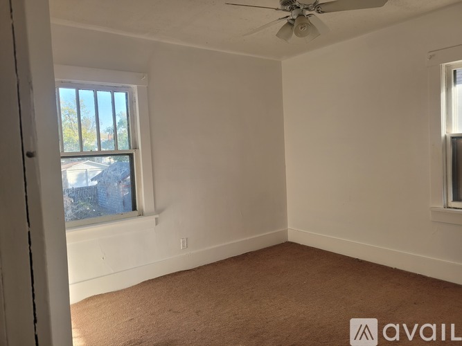 A room with a ceiling fan and a window.