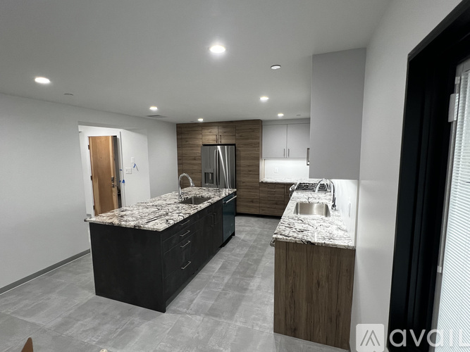 A modern kitchen with dark wood cabinets and granite countertops.