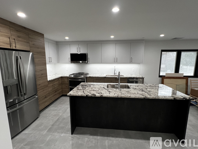 A modern kitchen with a granite countertop and stainless steel appliances.