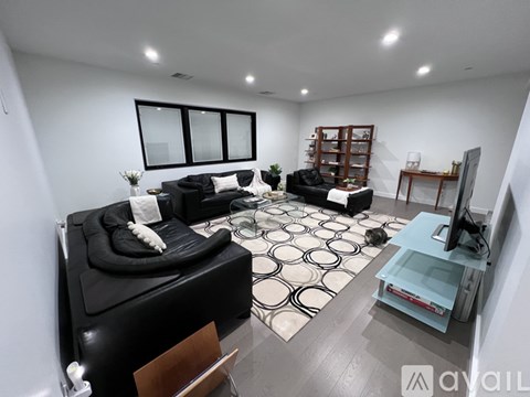 A living room with black and white decor and a television.