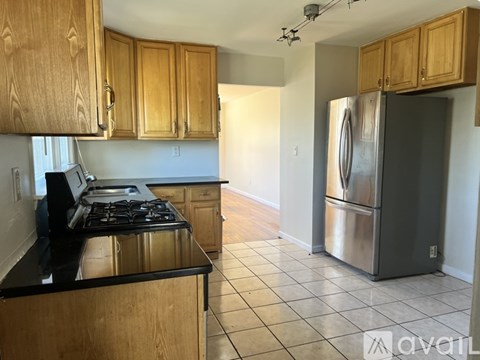 A kitchen with wooden cabinets and a stainless steel refrigerator.