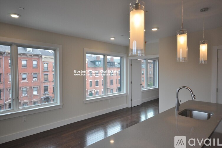 A kitchen with a large window overlooking a red brick building.