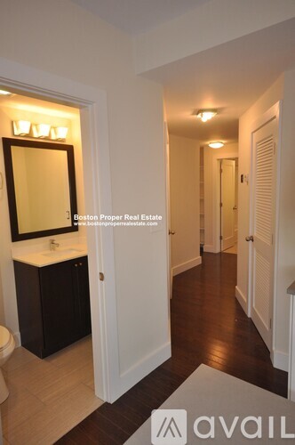 A bathroom with a toilet, sink, and mirror.