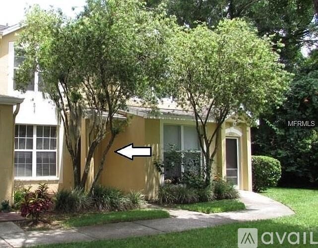 A house with a tree in front and a white arrow pointing to the left.