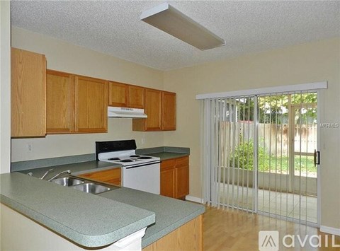 A kitchen with wooden cabinets and a white stove top oven.