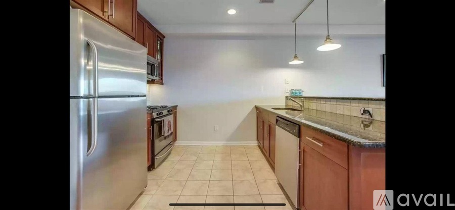A kitchen with a refrigerator, oven, and cabinets.