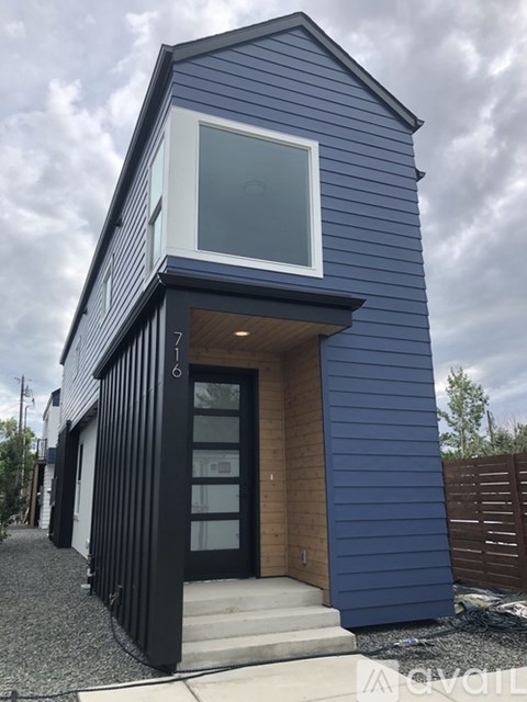 A modern house with a blue exterior and a large window.