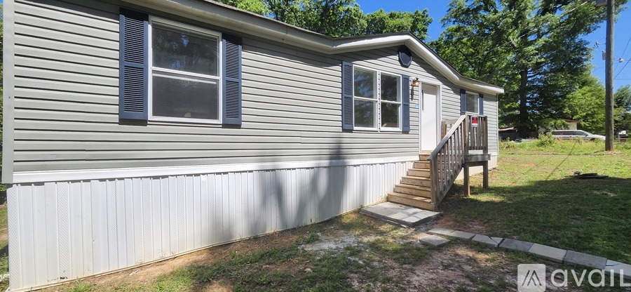 A house with a grey siding and a small porch.