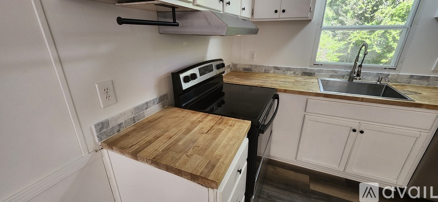 A kitchen with a black stove top oven and white cabinets.