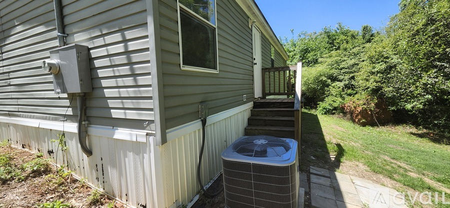 A house with a grey siding and a window is shown.