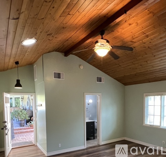A room with a wooden ceiling and a fan.