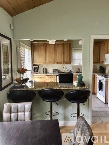 A kitchen with a table and chairs in front of it.