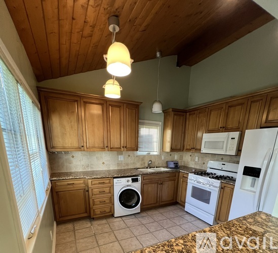 A kitchen with wooden cabinets and a white fridge.