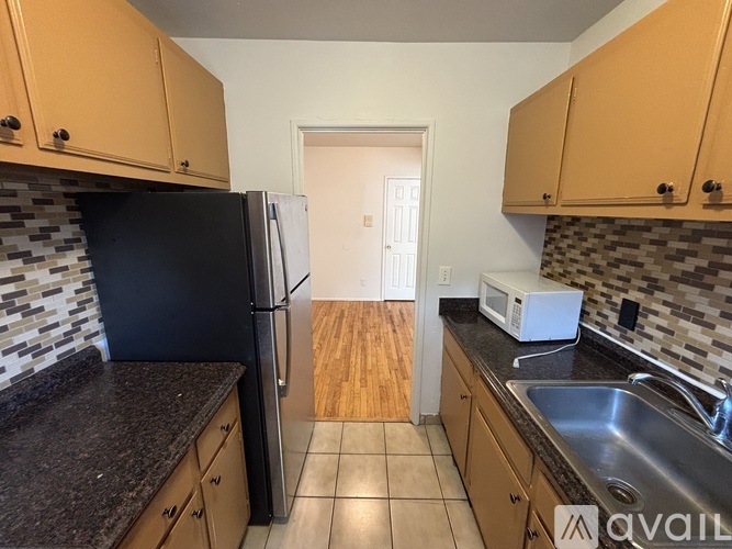 A kitchen with black appliances and wooden cabinets.