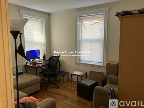 A living room with a desk and a chair.