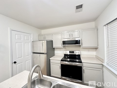 A kitchen with white cabinets and a black stove top oven.