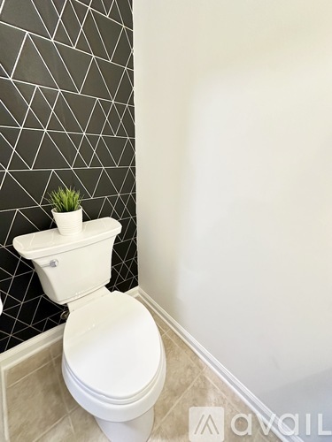 A white toilet with a plant on top of it.