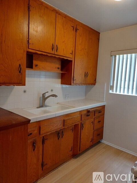 A kitchen with wooden cabinets and a white sink.