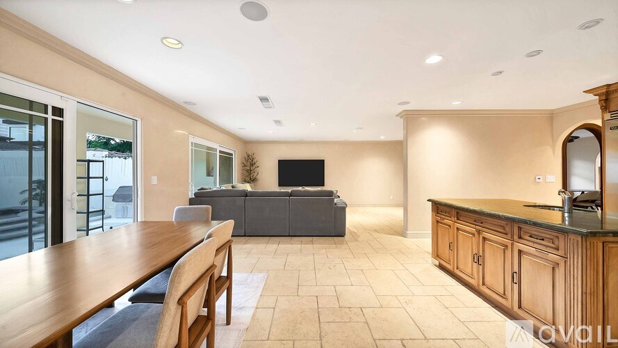 A modern living room with a wooden dining table and chairs.
