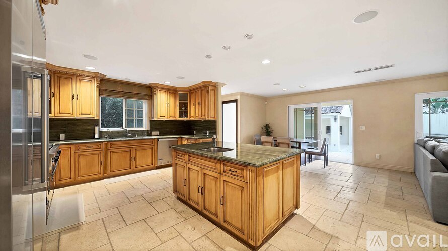 A kitchen with wooden cabinets and a marble countertop.