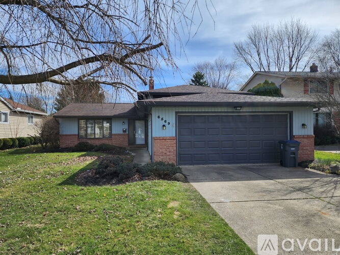 A house with a garage and a driveway in front.