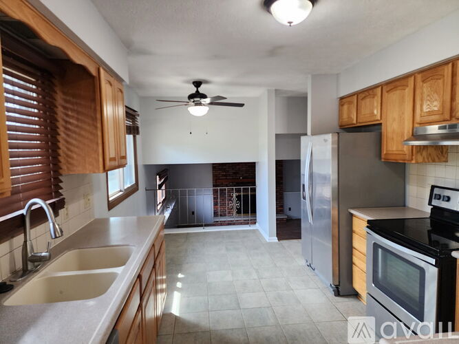 A kitchen with wooden cabinets and a stainless steel refrigerator.