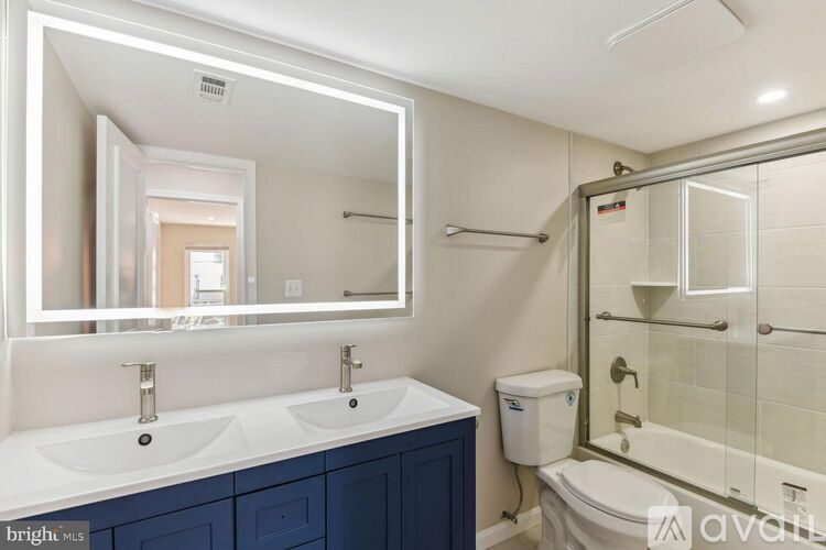 A bathroom with a double sink vanity and a glass shower stall.