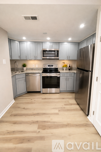 A kitchen with wooden floors and stainless steel appliances.