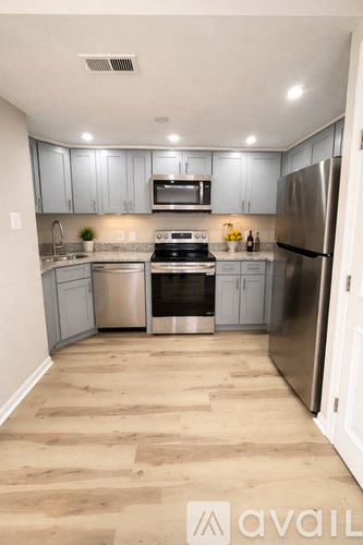 A kitchen with wooden floors and stainless steel appliances.