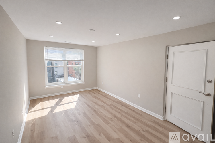 A room with wooden flooring and a large window.