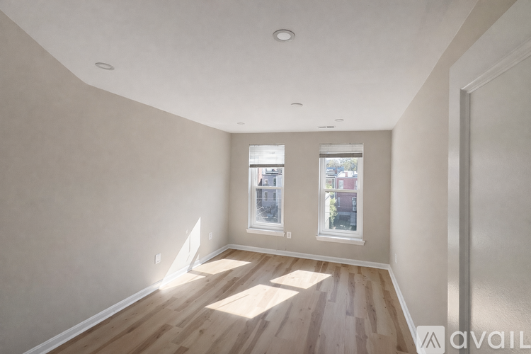 A room with wooden floors and two windows.