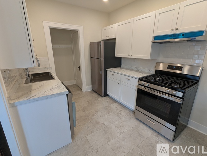 A kitchen with a refrigerator, oven, and sink.