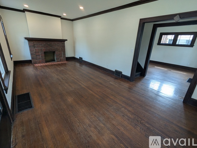 A room with a fireplace and wooden floors.