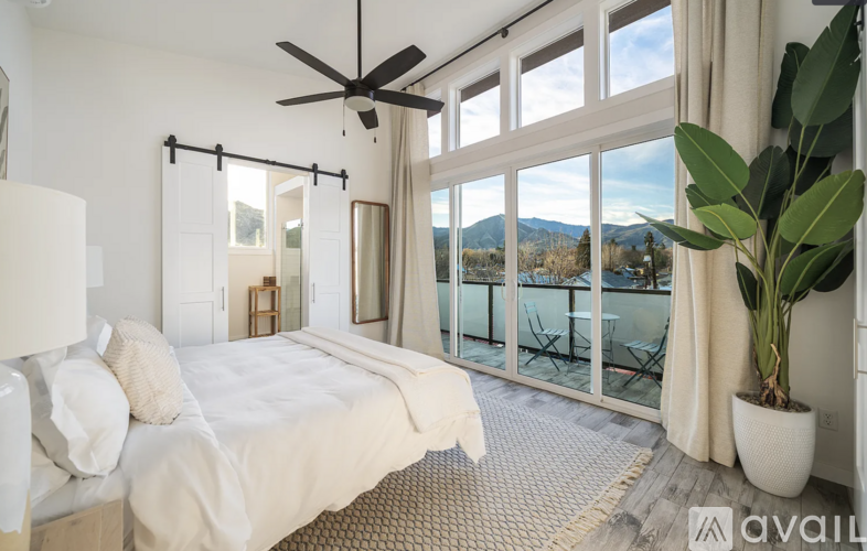 A bedroom with a large bed and a ceiling fan.