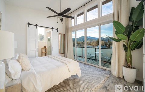 A bedroom with a large bed and a ceiling fan.