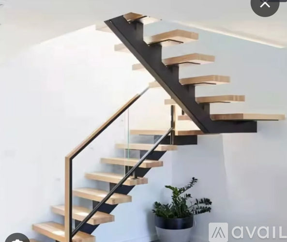 A wooden staircase with a glass balustrade.