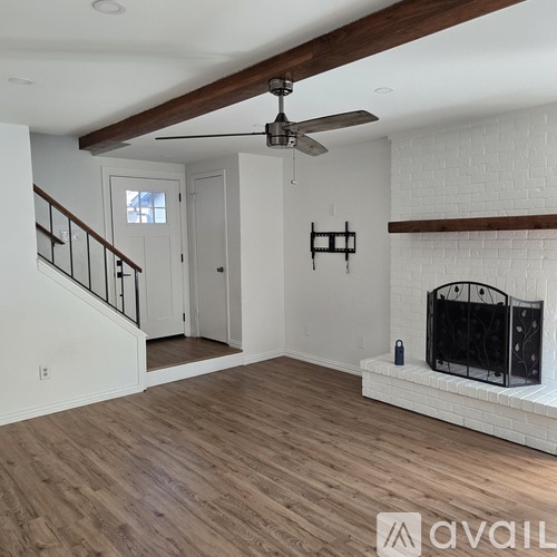 A living room with a fireplace and a ceiling fan.