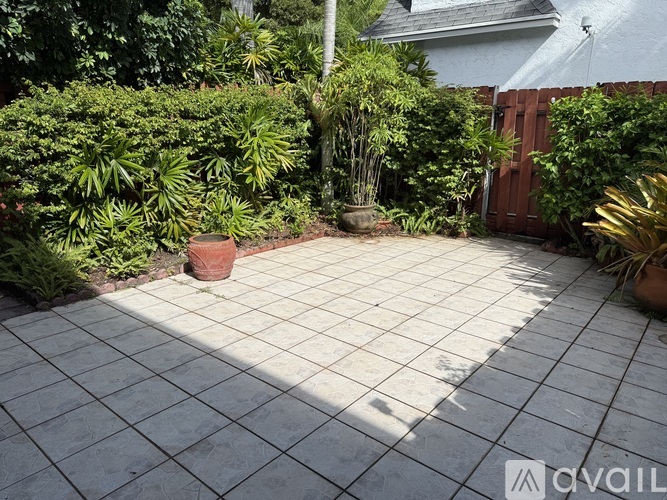 A patio surrounded by green plants and trees.