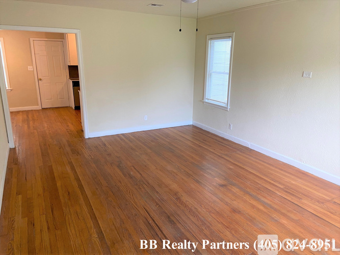 A room with wooden flooring and a white wall.