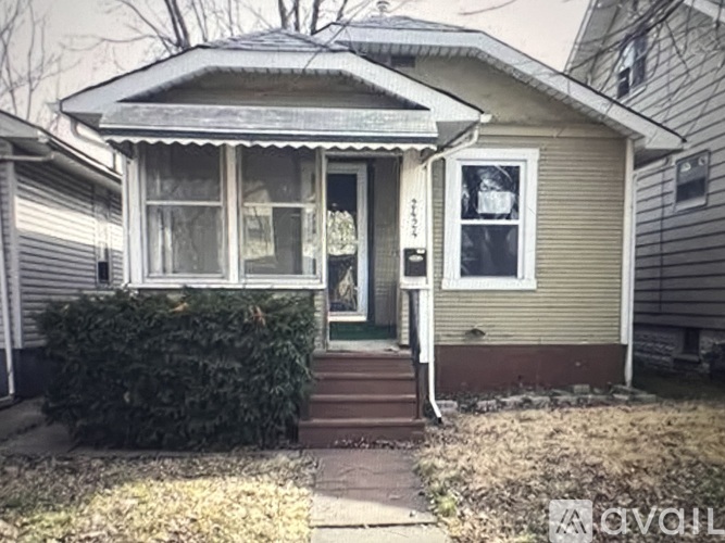 A small house with a front porch and a small window on the side.
