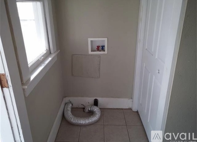 A small room with a window, a door, and a picture on the wall.