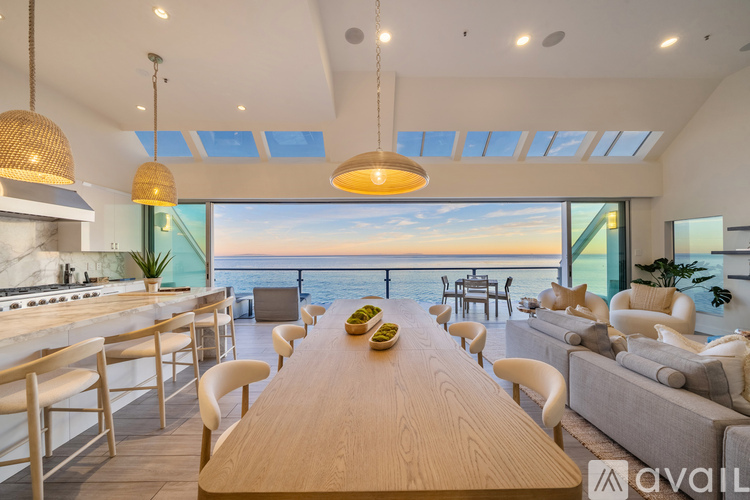 A modern dining area with a long wooden table and chairs.