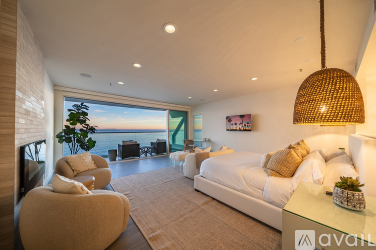 A modern bedroom with a large bed and a view of the ocean.