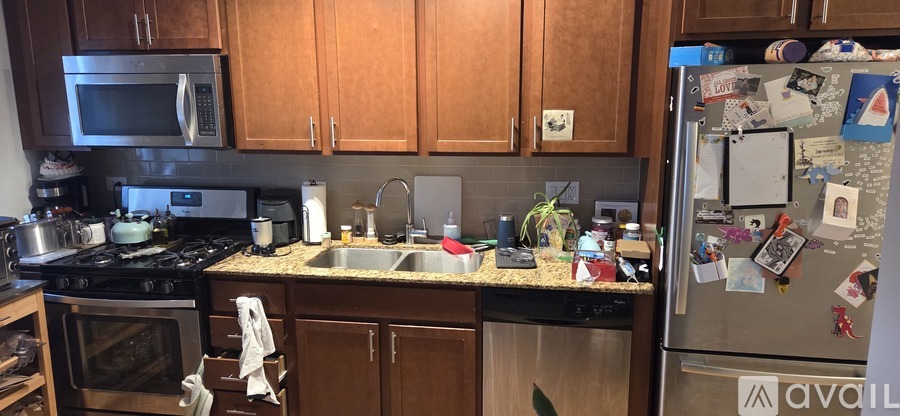A kitchen with a refrigerator covered in magnets and notes.