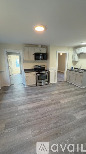 A kitchen with a microwave, oven, and sink.