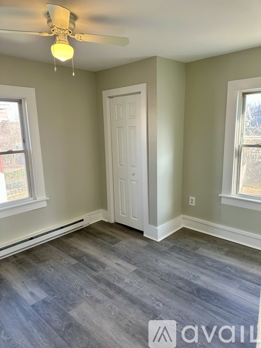 A room with a white door and a ceiling fan.