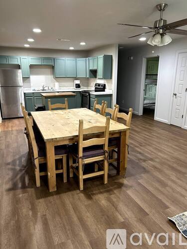 A kitchen with a table and chairs in the foreground.